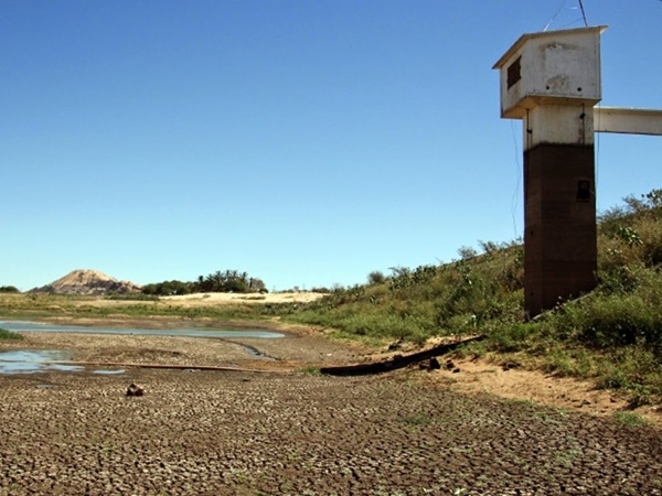 Açude seco no Semiárido, com lama rachada e apenas uma poça de água