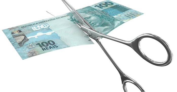 Tesouro cortando uma cédula de cem reais